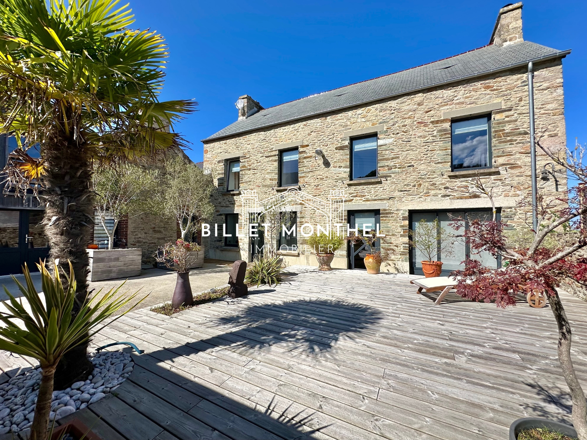 vue extérieur maison en pierre rénovée vue mer bretteville terrasse en bois